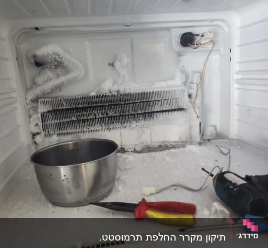 תיקון מקרר עם כלים, קרח וחוטים חשמליים
